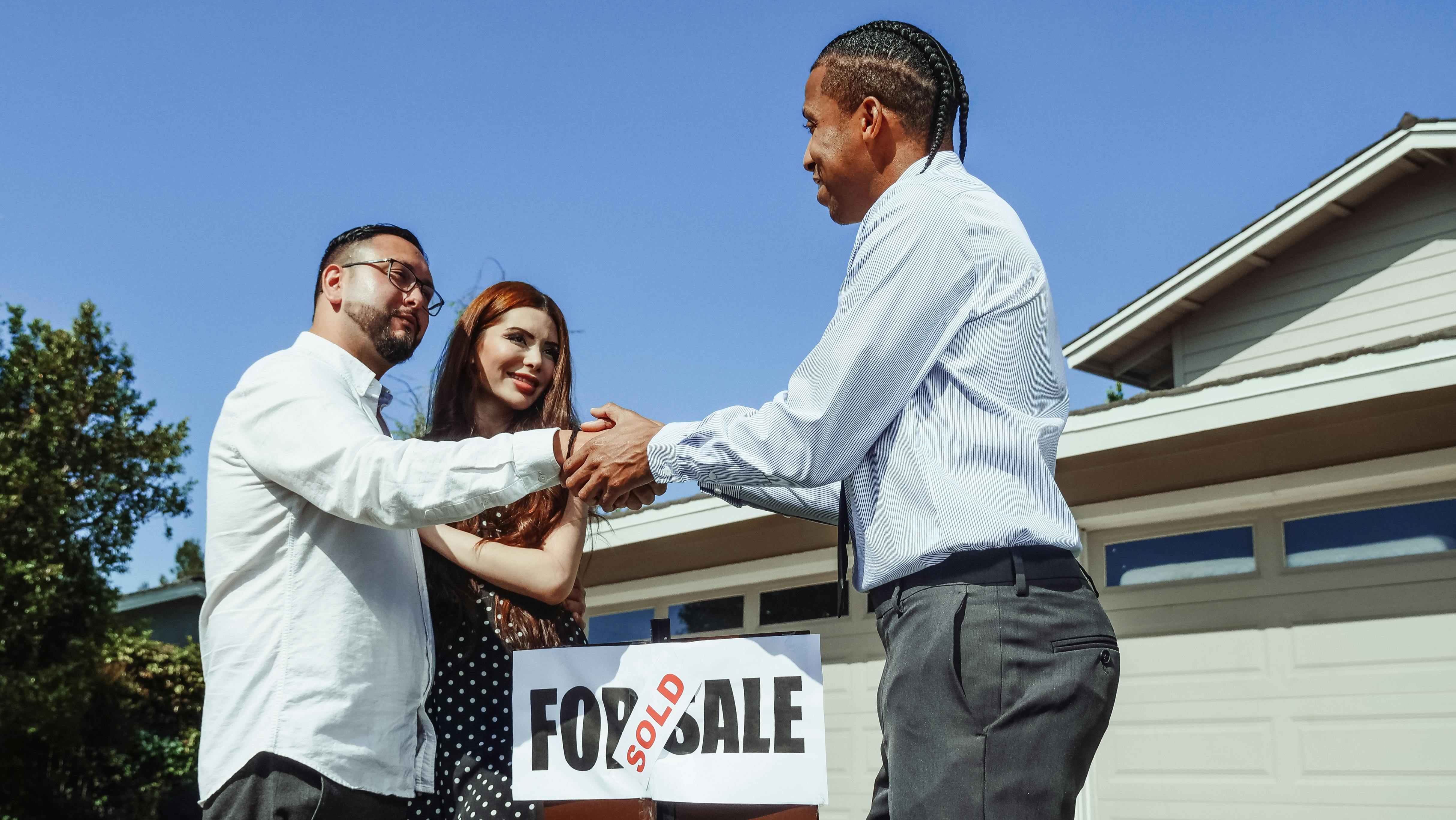 Couple shaking hands with realtor