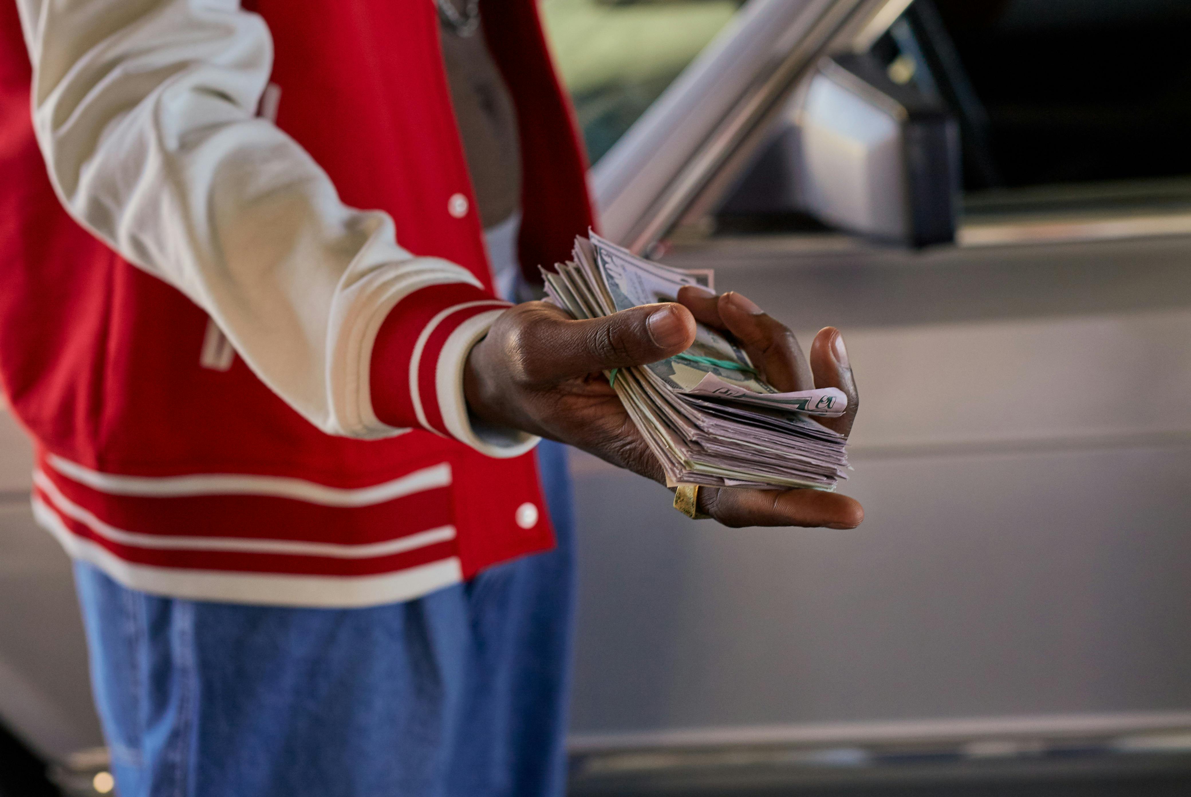 Person offering a stack of cash