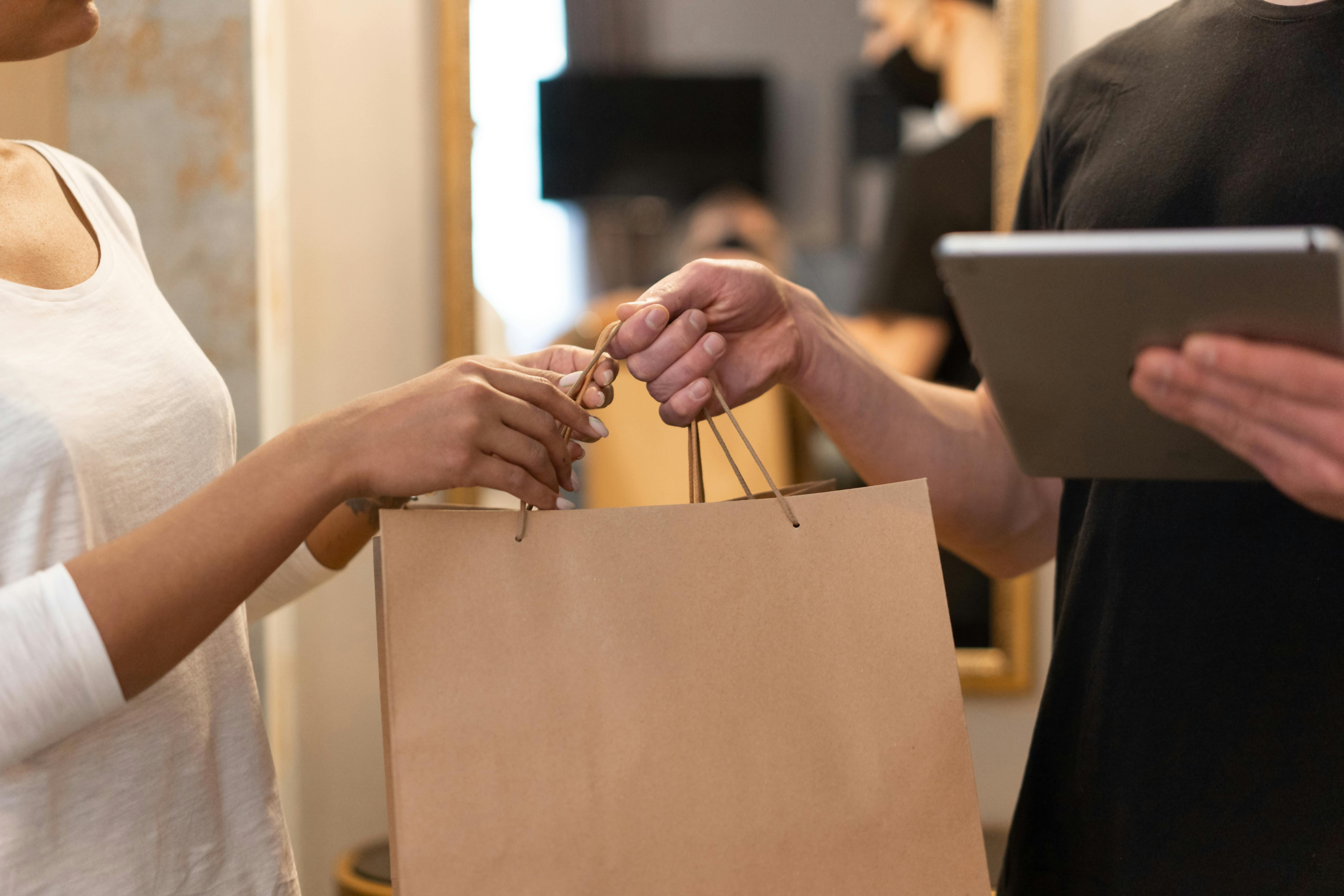 Hands exchanging a shopping bag