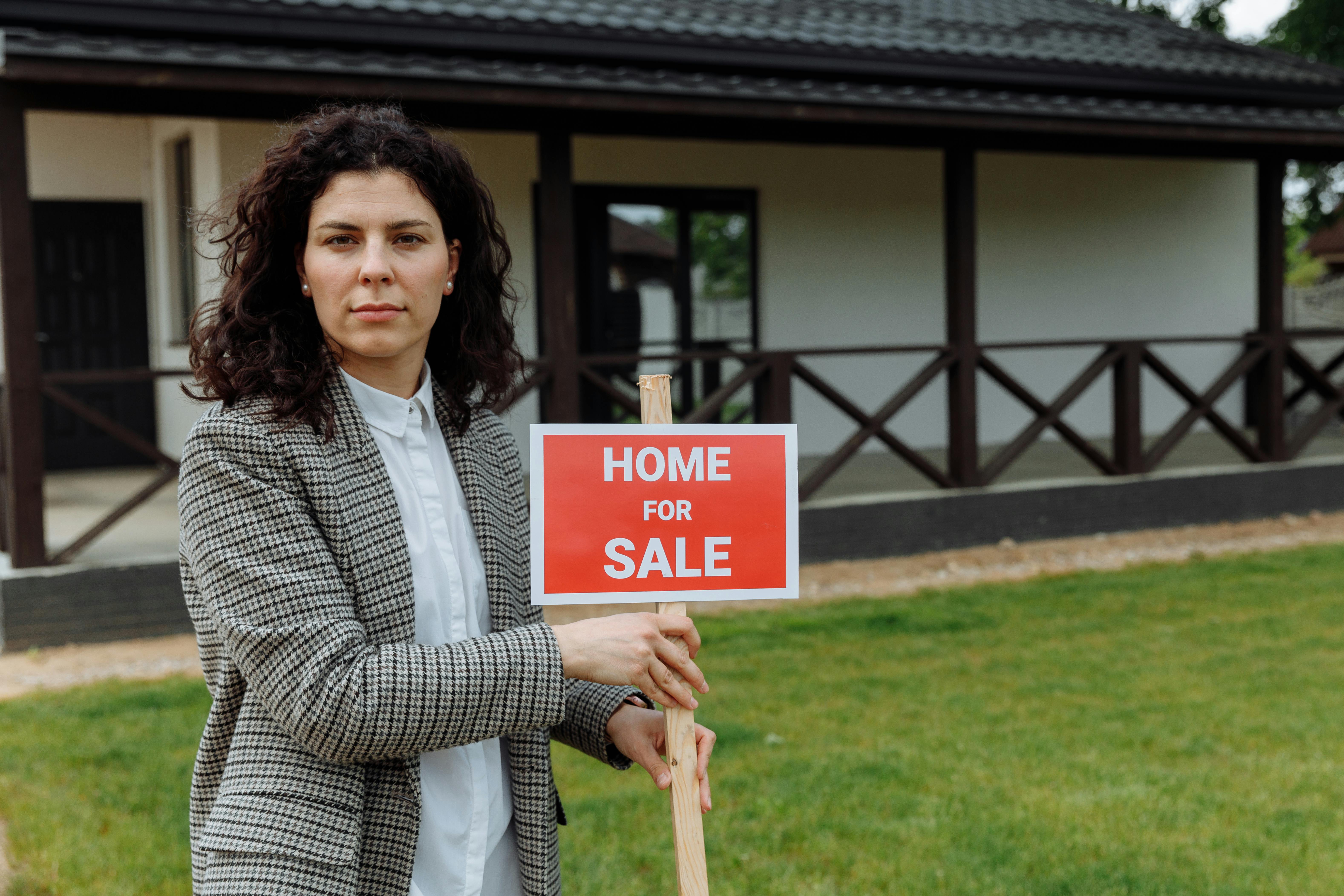 Real estate agent with sale sign