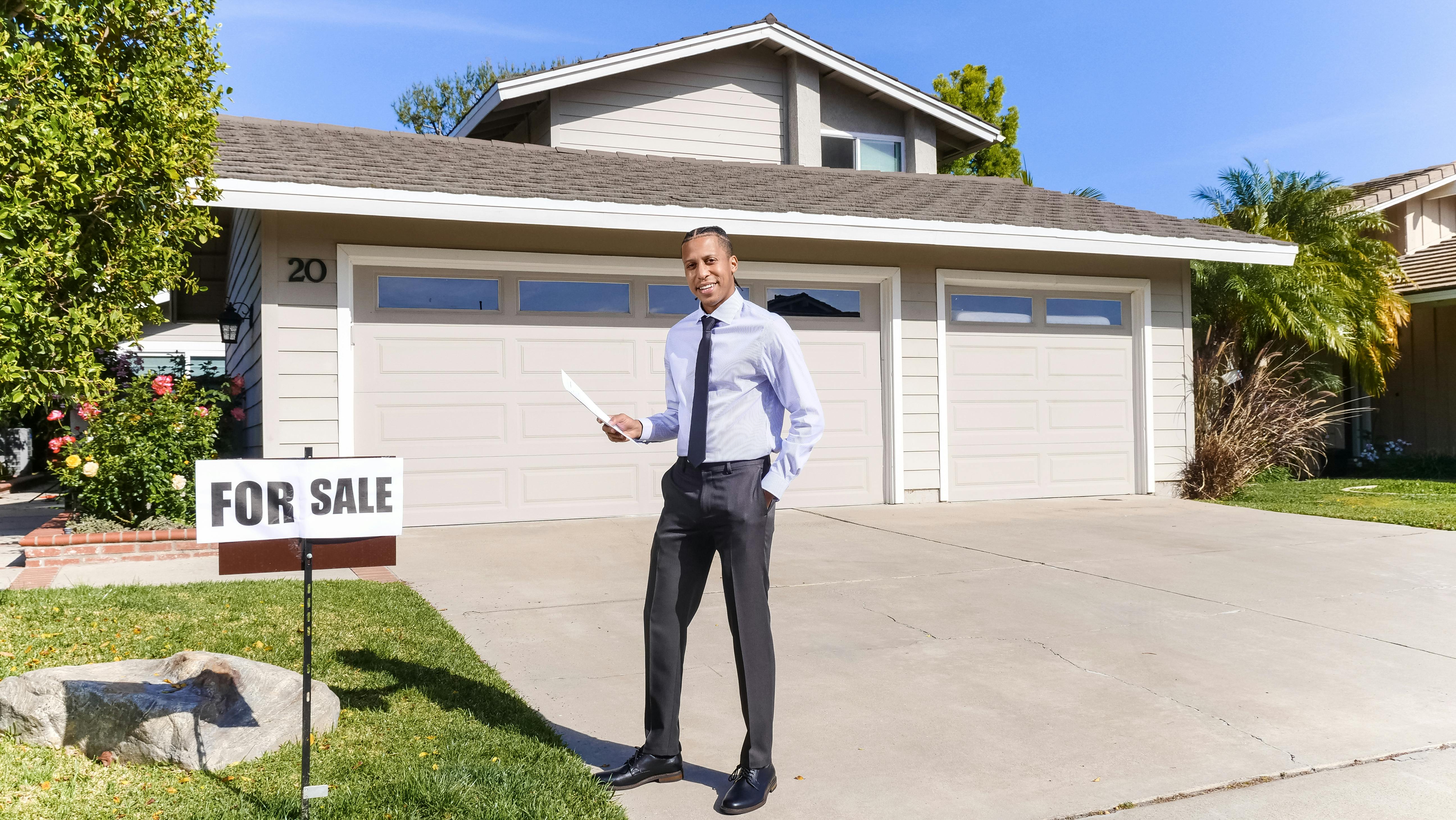 Real estate agent with a for sale sign