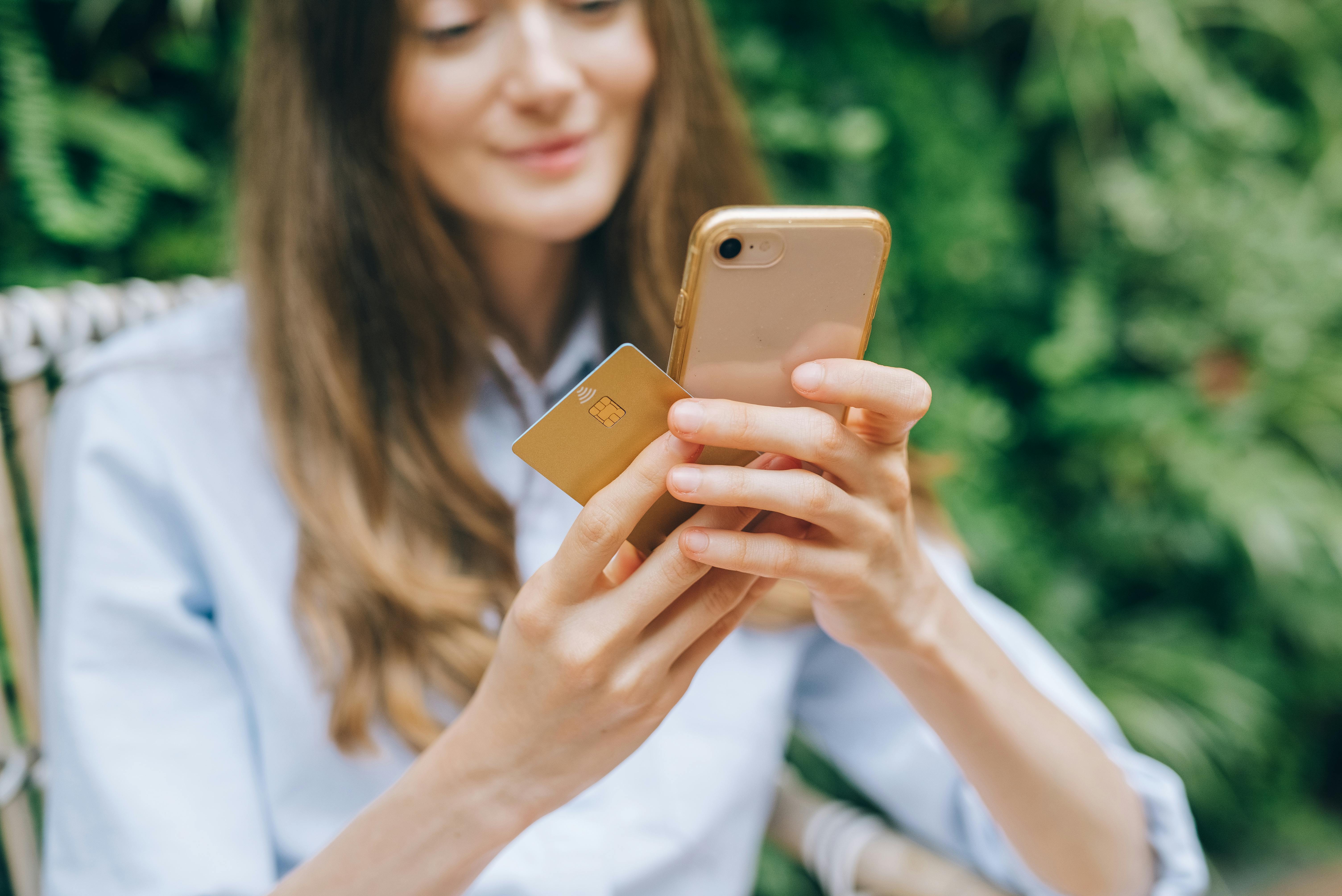 Woman using smartphone and credit card